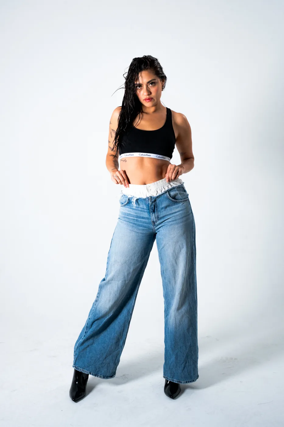Full-length, hands behind the head, wide-leg jeans