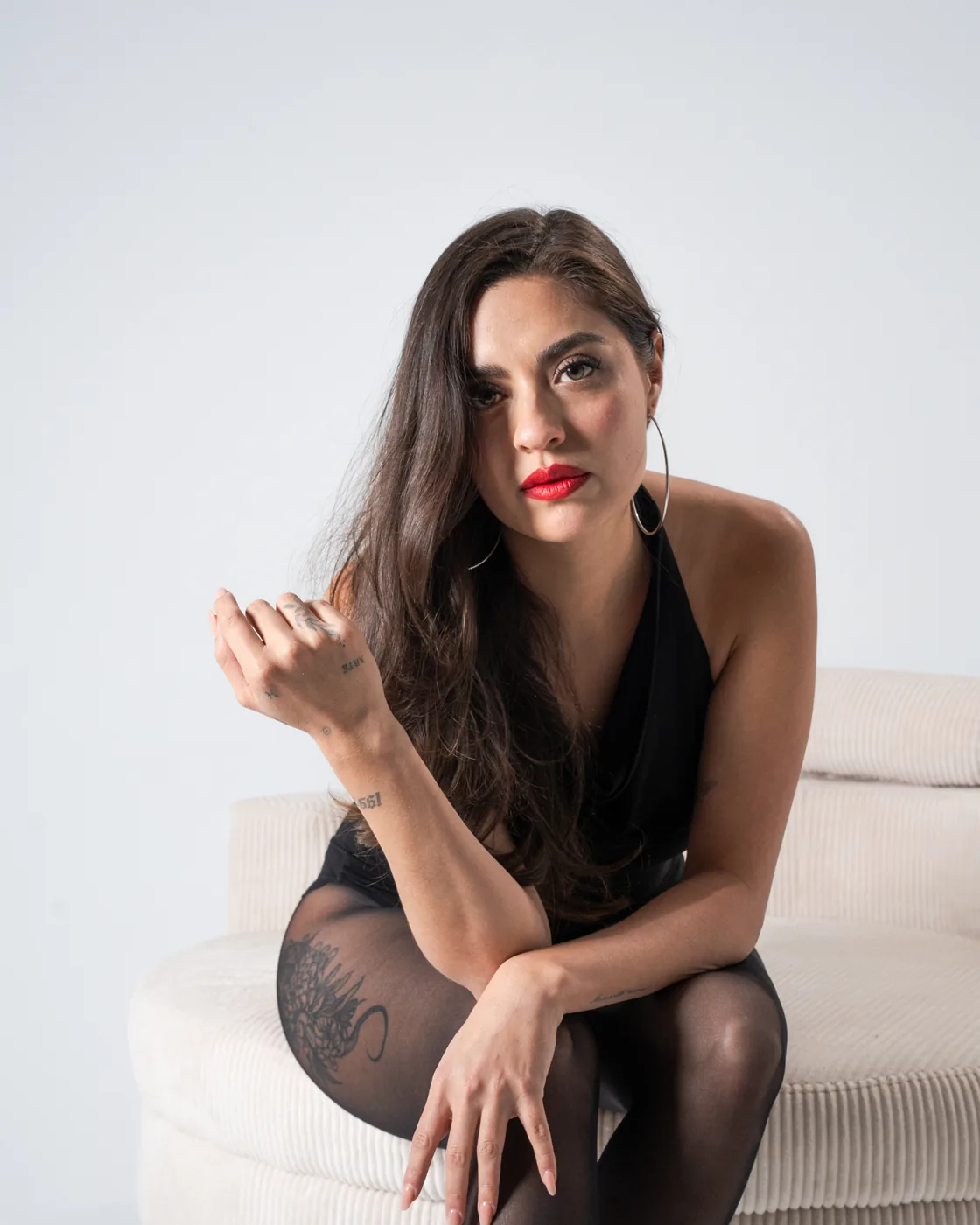 Close-up with red lips, seated on a cream sofa